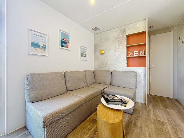 Una sala de estar moderna con un sofá modular, una mesita de madera y una estantería con la palabra