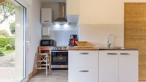 A compact kitchen with a microwave, stove, and sink.