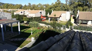 A residential area with stone buildings, a tiled roof, and a garden with a table and chair.