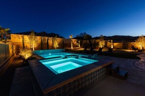 Zona de piscina exterior climatizada con sillas de descanso y una terraza.