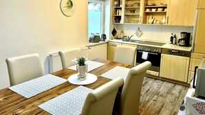 A compact kitchen with wooden cabinets, a built-in oven, and a sink. - Holiday Apartment Weißer Hirsch in House Sabine (Braunlage)
