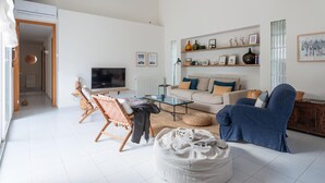 A modern living room with a sofa, chairs, a coffee table, and a television.
