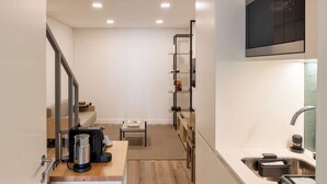 A modern kitchen with a built-in microwave, a sink, and a coffee maker on the counter. - Fervença Boutique Palace 1 by HostWise (Vila Nova de Gaia)