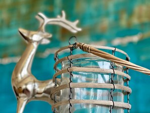 A decorative metal deer sculpture with a drum and a stick.