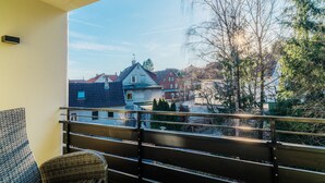 A balcony with a view of a residential area, including houses and trees. - Holiday Apartment "Fichte" (Braunlage)