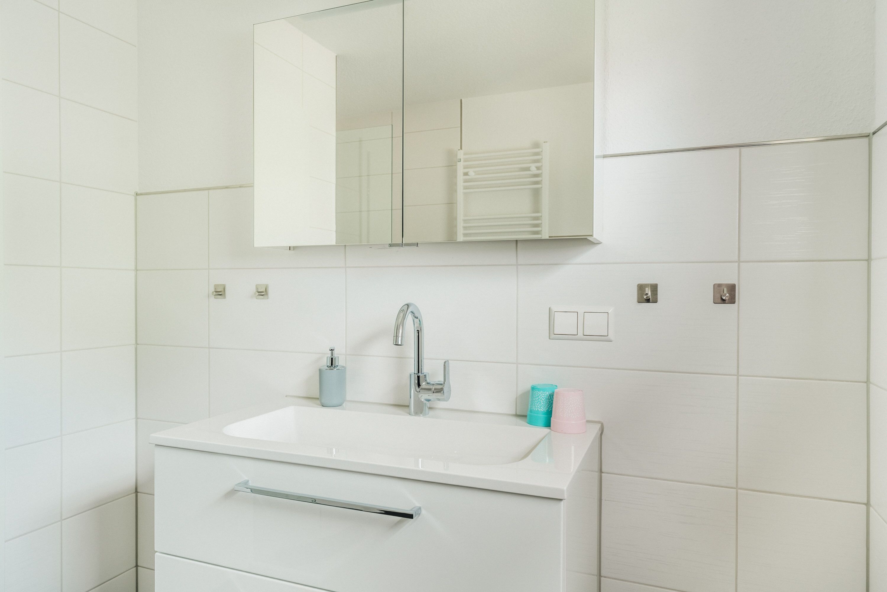 Ein Badezimmer mit Waschbecken, Spiegel und Handtuchhalter.