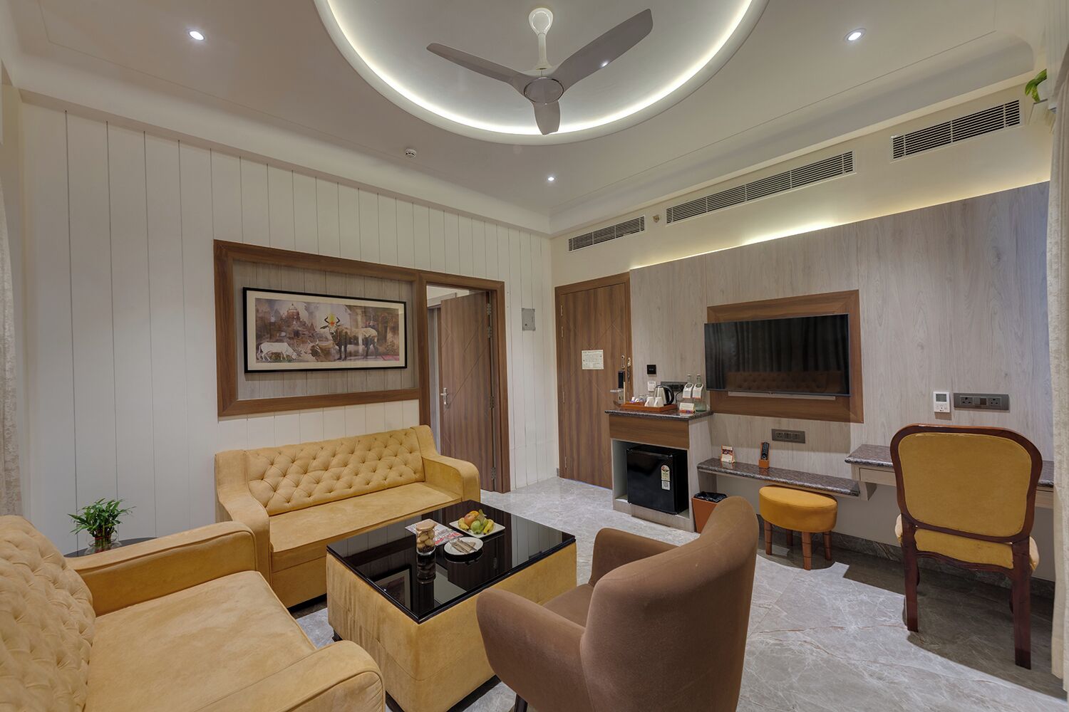 Una sala de estar moderna con un sofá, sillones, una mesa de centro y un televisor.