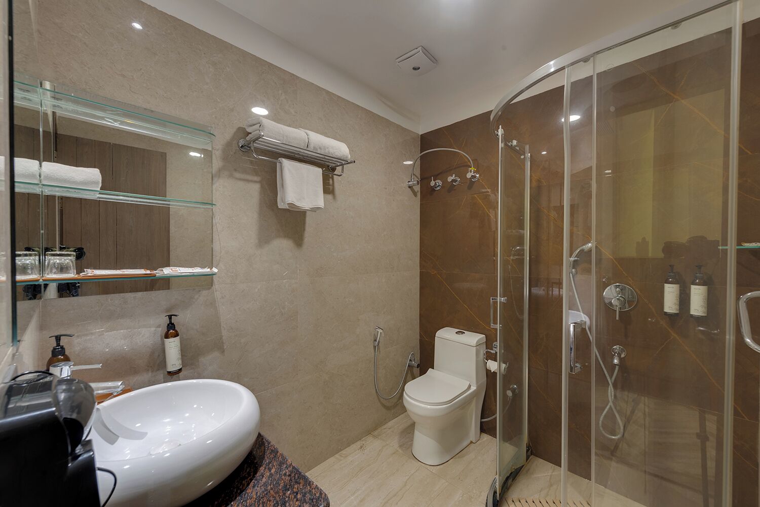 Une salle de bain moderne avec une douche à parois de verre, un lavabo blanc et des toilettes.