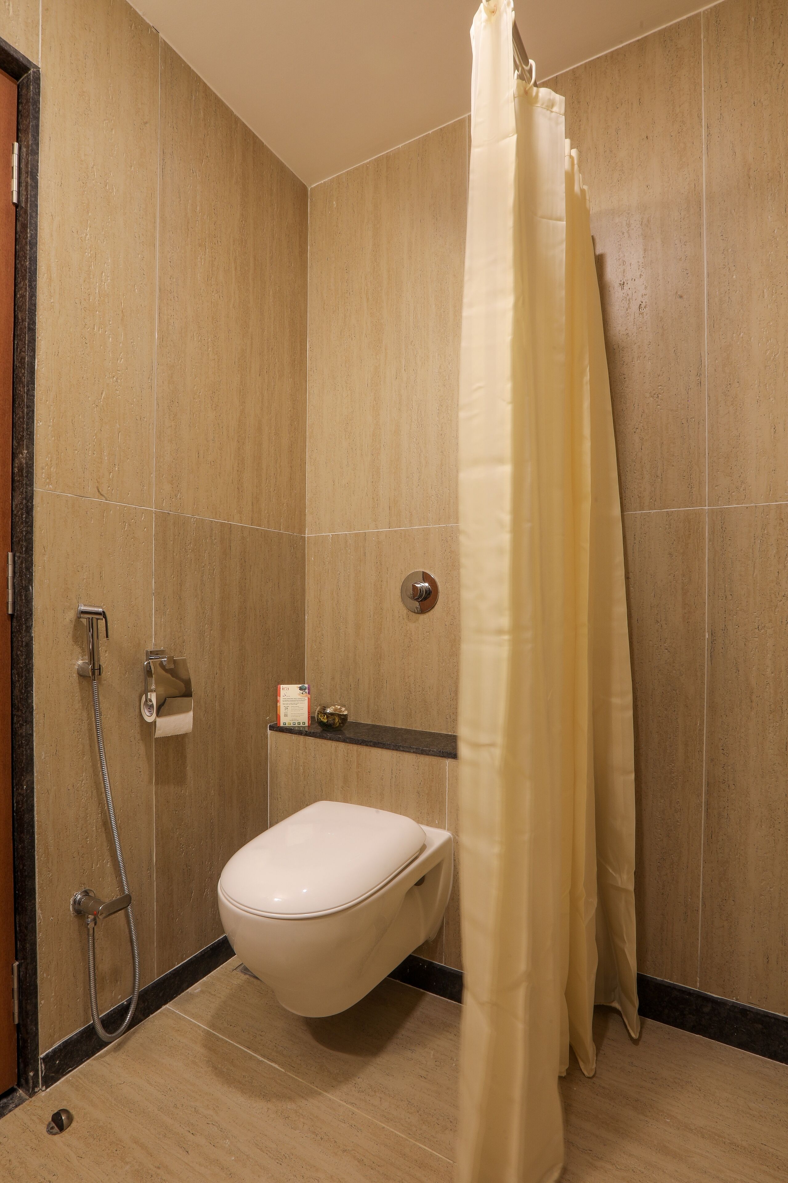 A modern bathroom with a toilet, shower, and a towel rack.