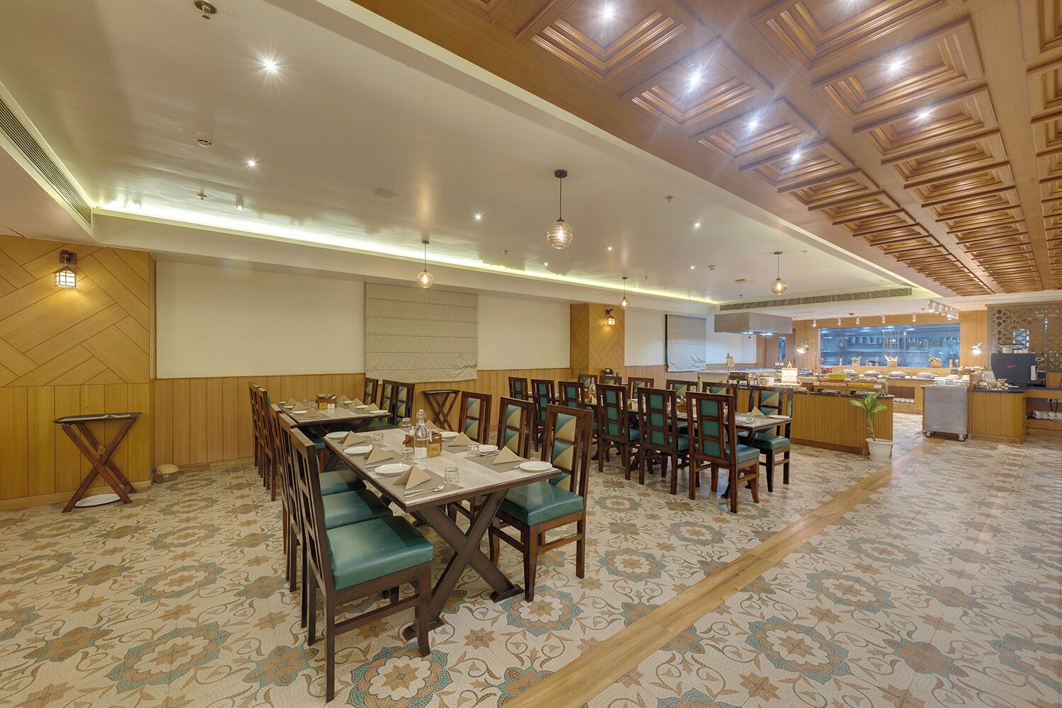 Un restaurant avec un plafond en bois, des chaises rembourrées de couleur verte et un tapis à motifs.