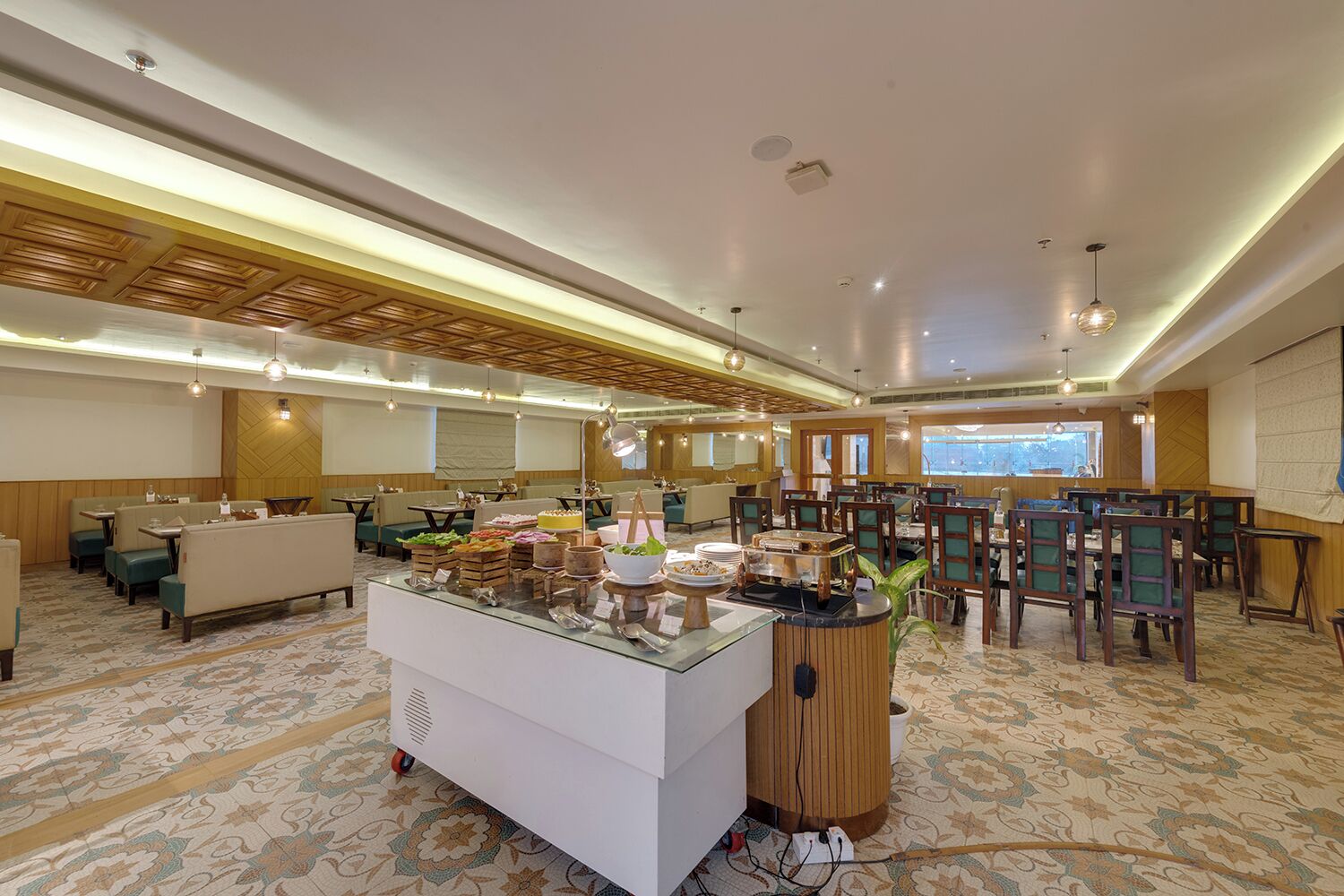 A hotel dining area with multiple seating options, a buffet station, and a large window providing a view.
