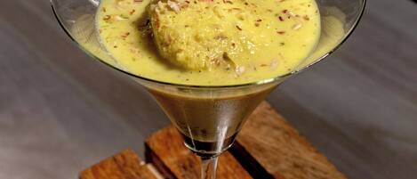 A dessert in a martini glass on a wooden surface.