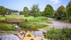 A serene park with a pond, a wooden bridge, and a paved walkway. - Beautiful apartment in Attendorn (Attendorn)