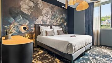 Un dormitorio moderno con una cama grande, una lámpara de pared y vistas al exterior.