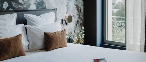 Un dormitorio moderno con una cama grande, un mural en la pared y vistas al exterior.