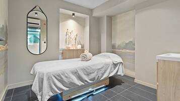 A modern bedroom with a bed, a mirror, a vanity, and a wall-mounted air conditioner.