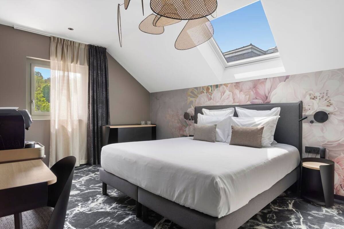 Un dormitorio moderno con una cama grande, un escritorio y una silla.