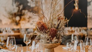 A dining table with a centerpiece of dried flowers and branches, surrounded by empty wine glasses. - Hôtel Le Rituel Honfleur (Honfleur)