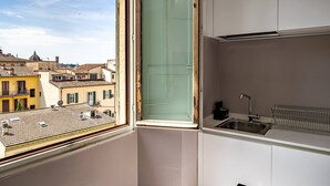 A kitchen with a window, a sink, and a view of buildings.