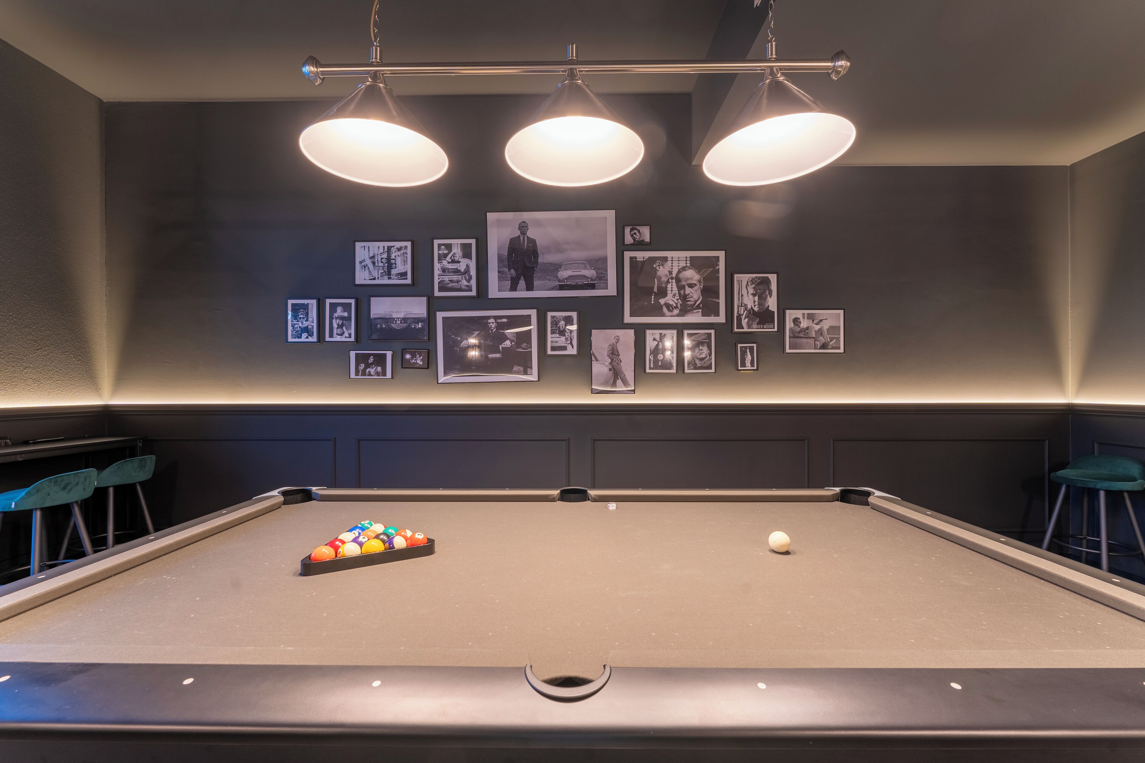 Ein Billardtisch mit Spielball und Billardkugeln, umgeben von blauen Barhocker.