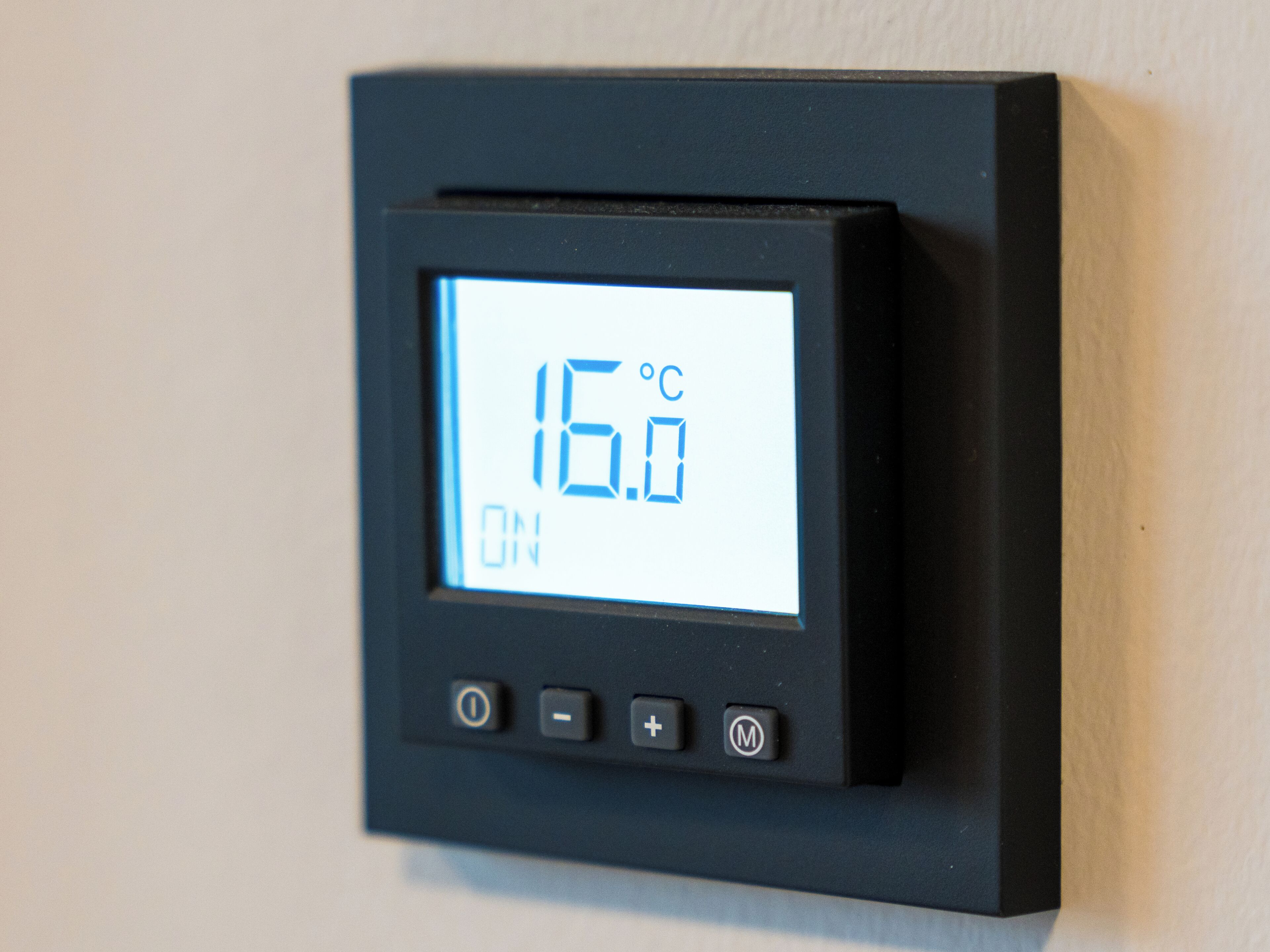 A digital thermostat displaying 16.0°C with a power button, temperature adjustment buttons, and a mode button.