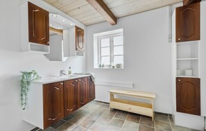 Une salle de bain moderne avec des meubles en bois, un lavabo blanc et une fenêtre.