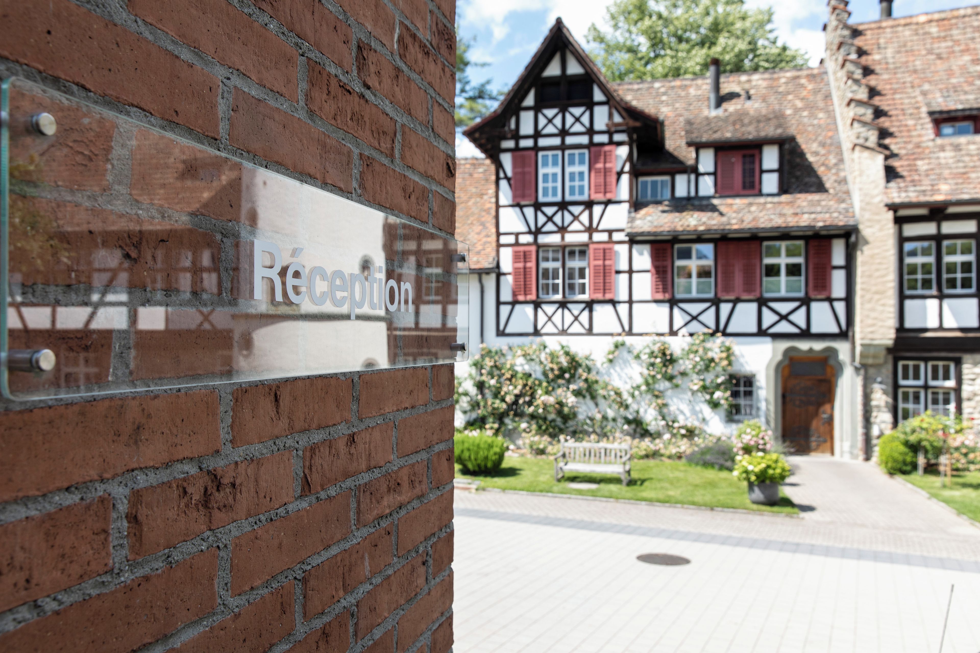 Ein Empfangsbereich mit Backsteinwand und einem Schild.