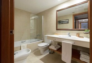 Bathroom features a large mirror, sink, shower with glass door, and bidet, along with a convenient towel shelf.