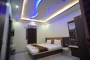 Quarto de hotel moderno com cama, mesa de cabeceira, ar condicionado e um espelho.