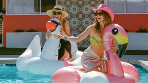 Two people in a swimming pool with inflatable flamingo floats. - The Sofia Suite · Adults-Only Palm Springs Pool (Palm Springs)