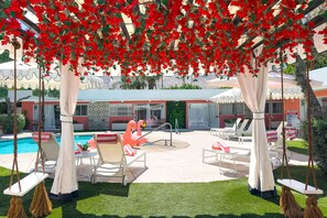 A poolside area with lounge chairs, a flamingo float, and a swing set. - The Sophia Suite · Adults-Only Palm Springs Pool (Palm Springs)