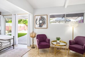 A modern room with a bed, purple armchairs, a round table, a floor lamp, and a large abstract painting. - The Sofia Suite · Adults-Only Palm Springs Pool (Palm Springs)