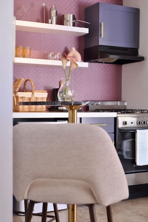 Eine Küche mit modernem Design, inklusive Herd, Backofen und einem Schrank über der Arbeitsfläche.