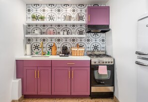 A kitchen with purple cabinets, a gas stove, and a built-in oven. - Brigitte Suite · Dog-Friendly Yard, Palm Springs (Palm Springs)