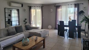 Una sala de estar moderna con sofá, mesa de centro y comedor.