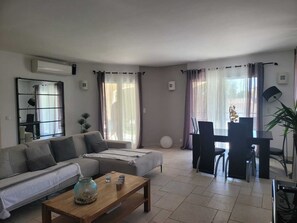 Un soggiorno moderno con divano, tavolino e zona pranzo.