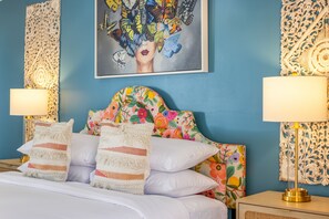 A bedroom with a blue wall, a floral headboard, white bedding, and two bedside lamps. - The Taylor Suite · Dog-Friendly Yard, Palm Springs (Palm Springs)