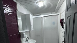 A compact bathroom with a toilet, sink, and shower stall. - UMK Pansiyon (Usak)