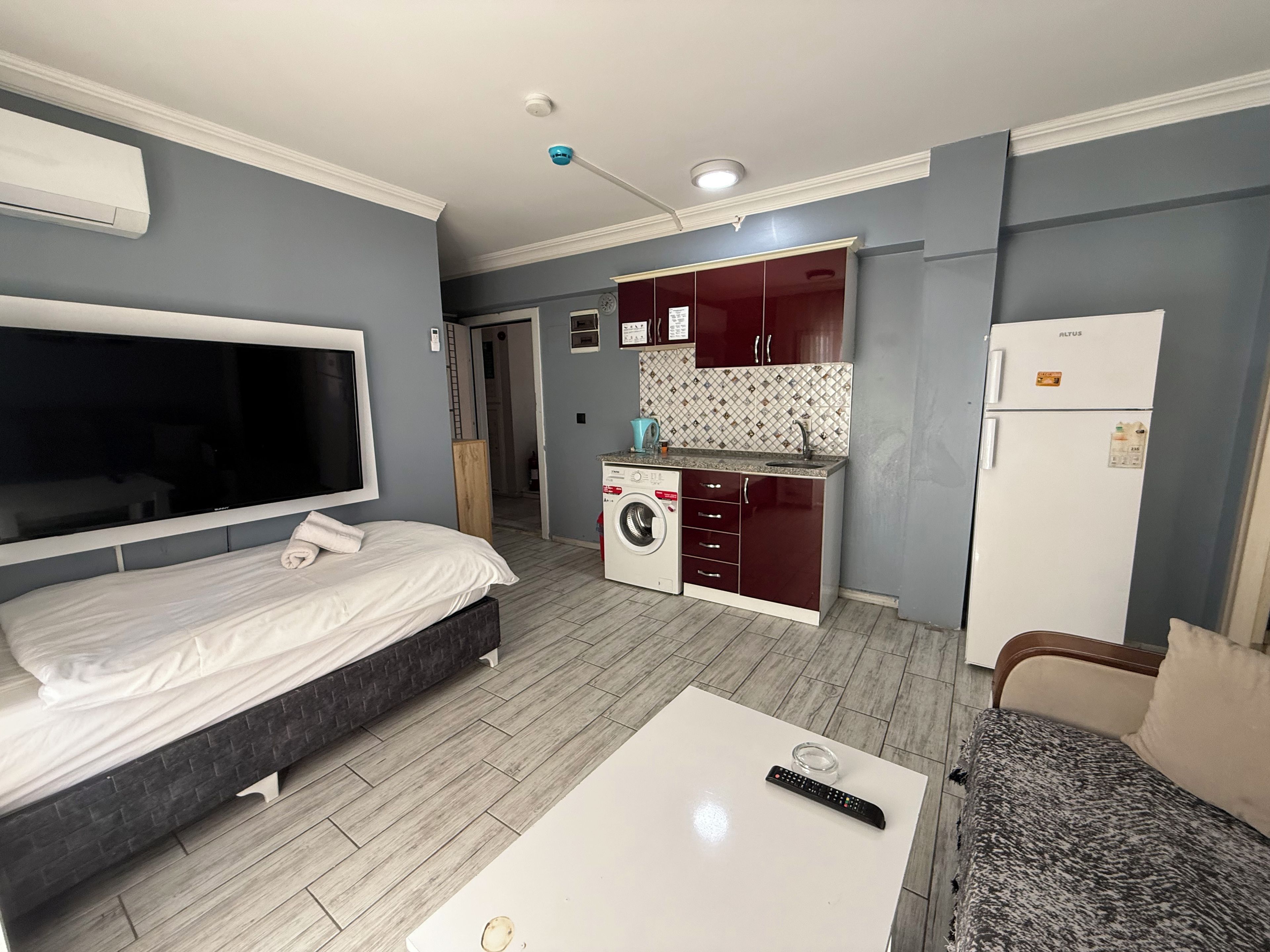 Une chambre d’hôtel équipée d’un lit, d’une télévision, d’un lave-linge et d’une kitchenette.