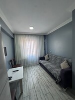 Una sala de estar pequeña y moderna con un sofá, una mesita y una silla.