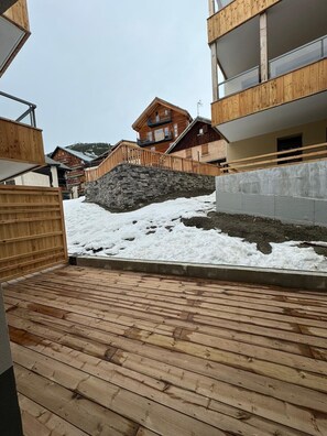 Surrounded by a deck and stone wall, this building offers a serene retreat with a balcony.