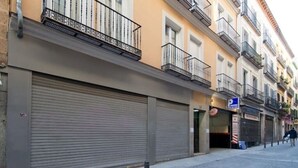 A street with closed storefronts, a visible parking sign, and a pedestrian walking in the distance. - Madrid - Studio BB Sol/gran Via (Madrid)