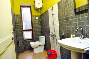 A bathroom with a toilet, sink, and shower. - Rufina Lachung Heritage (Chungthang)