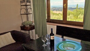 Una mesa de comedor con una botella de vino, copas y un plato.