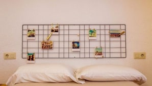 A bed with white bedding and a wall-mounted photo display. - Barcelona - Arte (Barcelona)