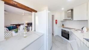 A modern kitchen with white cabinetry, a built-in oven, and a marble countertop. - La Manga Club El Rancho Townhouse 513 (Atamaría)