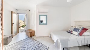 A bedroom with a bed, a ceiling fan, a window with a view, and a door leading outside. - La Manga Club El Rancho Townhouse 513 (Atamaría)