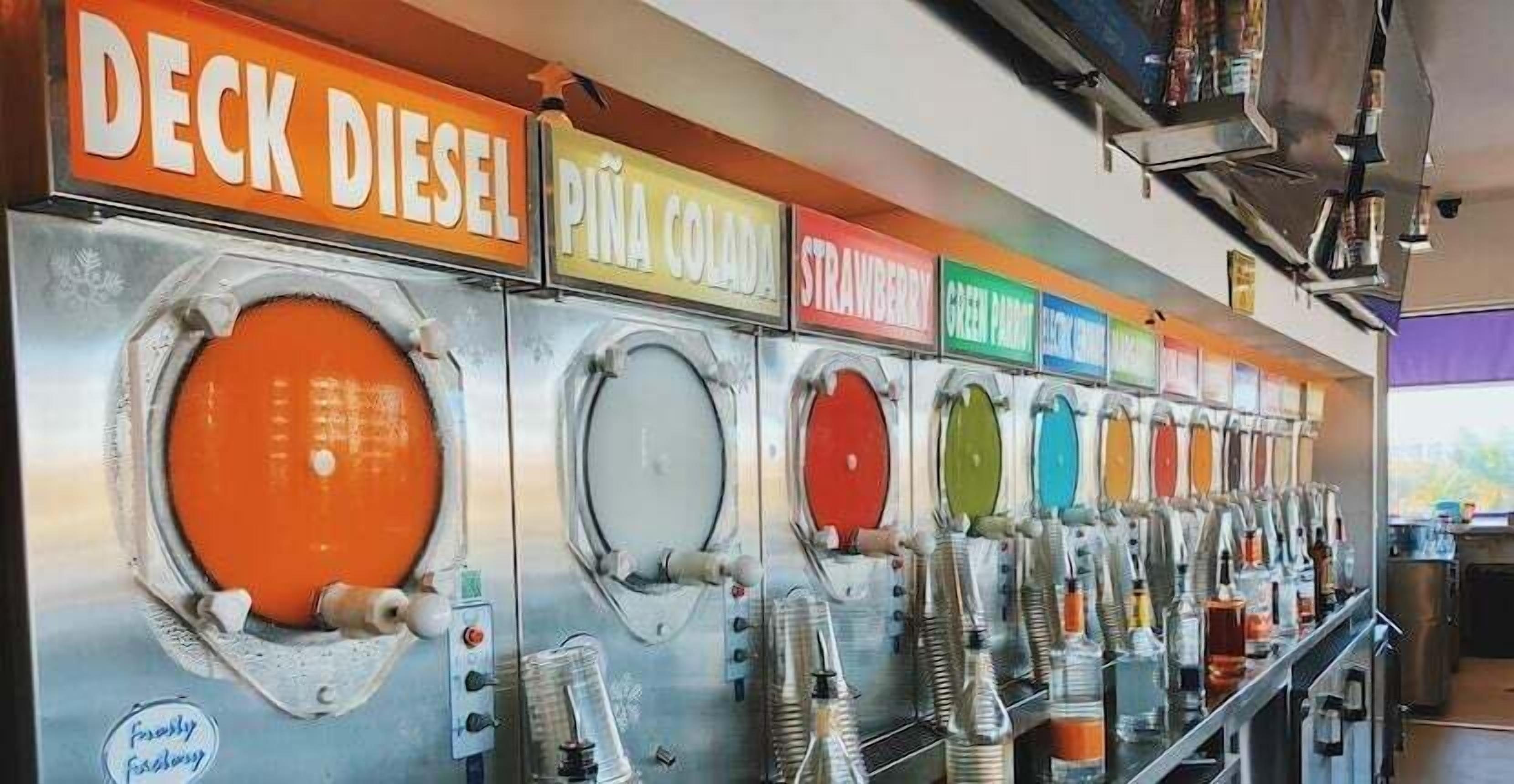 A row of beverage dispensers with labels for different drinks.
