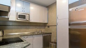 Una cucina moderna con elettrodomestici in acciaio inossidabile, tra cui un forno a microonde e un frigorifero, e un piano di lavoro in granito.