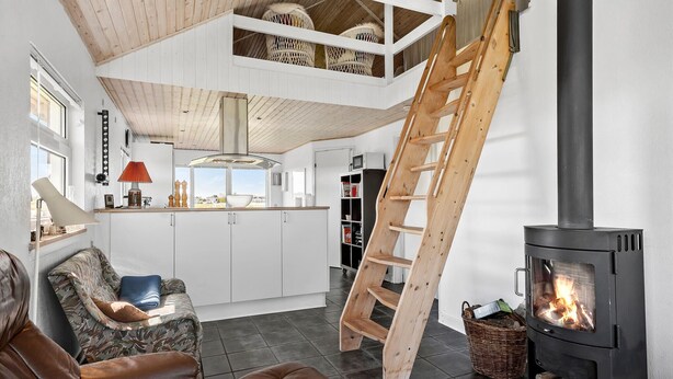 Un interior moderno con un entrepiso, una cocina y una sala de estar.